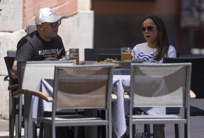 Una pareja come en una terraza del centro de la capital