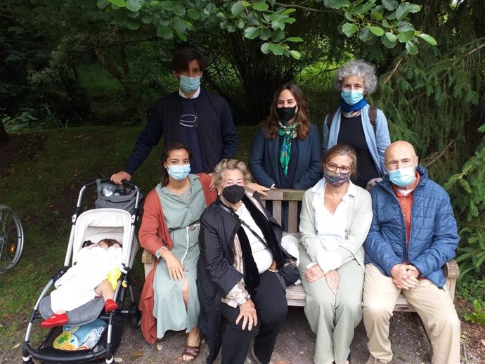 La viuda del arquitecto Juan González Moriyón y familia, en el descubrimiento de una placa como homenaje póstumo en un banco en el Botánico de Gijón