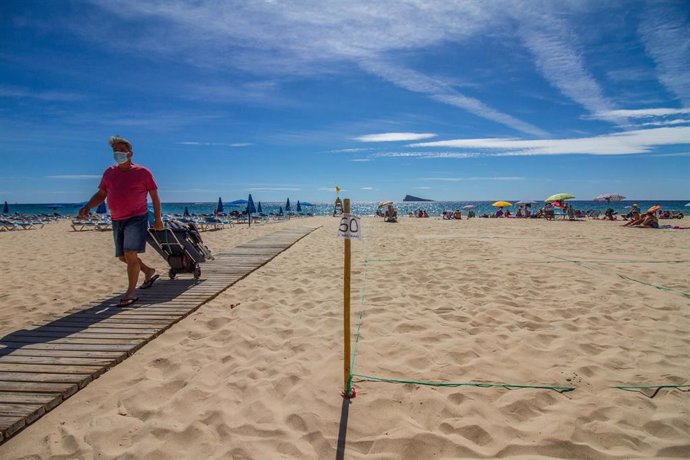 Archivo - Un hombre camina por la pasarela de la Playa de Levante de Benidorm durante el Día Mundial del Turismo 2020