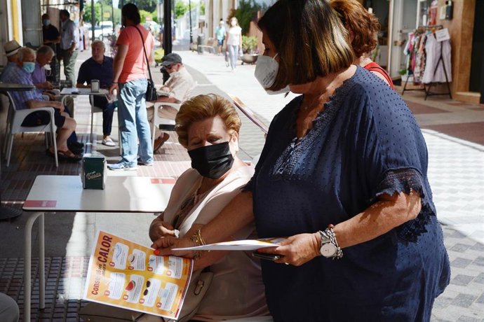 La concejal de Bienestar Social de Tomares, Maite Garay, repartiendo consejos frente al calor a los mayores