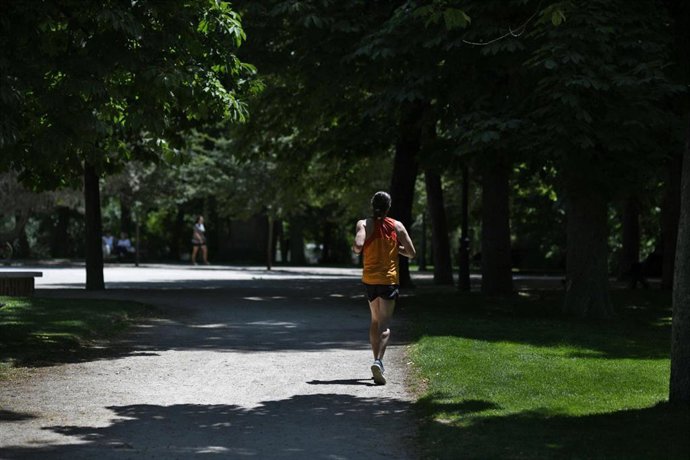 Archivo - Una mujer corriendo en el Parque del Retiro de Madrid.