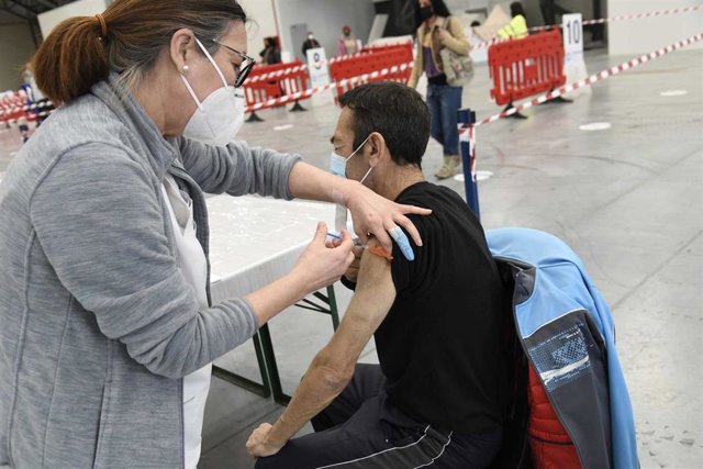 Archivo - Una sanitaria vacuna a una hombre en el Instituto Ferial de Vigo (Ifevi), en Pontevedra, Galicia (España), a 13 de marzo de 2021. Un total de 4.400 personas serán inmunizadas por un equipo de 60 profesionales sanitarios que administrarán la vacu