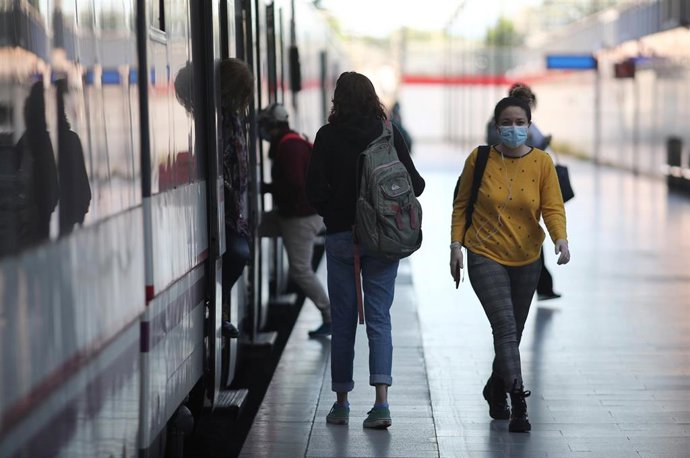 Archivo - Varias personas suben y bajan de un tren de Cercanías Madrid en un andén de la estación Príncipe Pío.