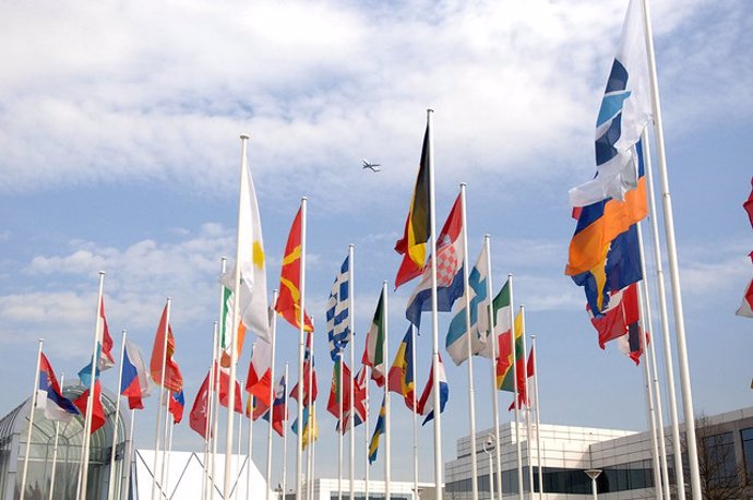 Archivo - Avión sobrevolando las banderas de la sede de Eurocontrol en Bruselas
