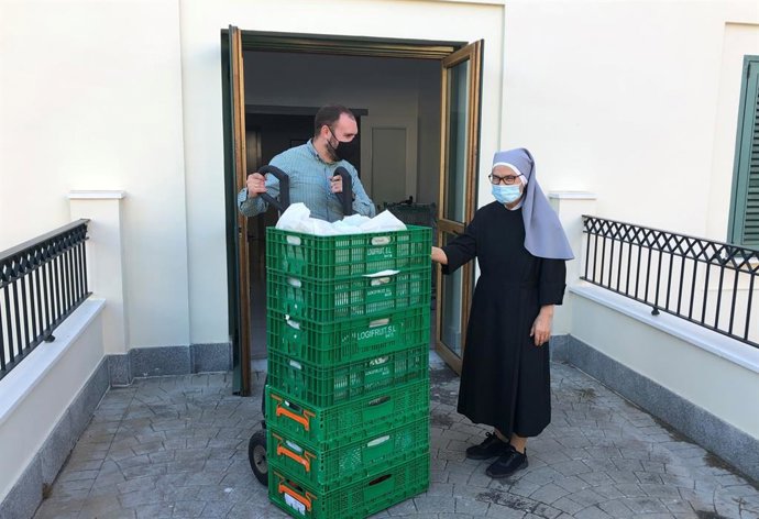 Alberto, uno de los trabajadores de Mercadona, entrega los productos a Sor María Isabel, Hermana de la congregación
