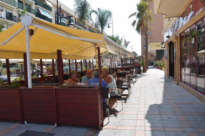 Archivo - Unos turistas aprovechan los últimos días del verano para tomarse un aperitivo en una terraza de Fuengirola.