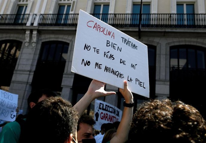Persona sujetando y levantando una pancarta frente a la Puerta del Sol para exigir una elección de plazas con garantías el 8 de junio de 2021, en Madrid (España). Organizada por la Confederación Estatal Sindicatos Médicos (CESM), con esta nueva protesta