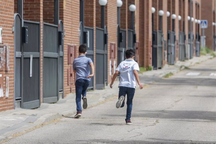 Archivo - Dos niños corren por una calle.