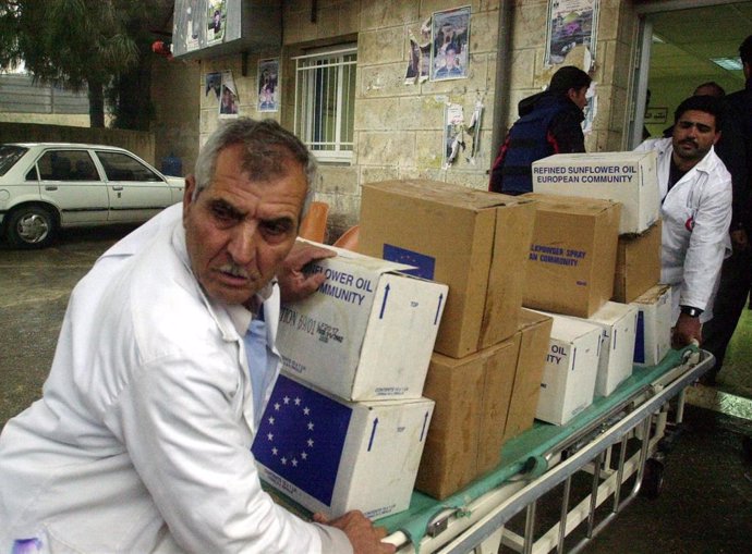 Archivo - Médicos palestinos ayudan a descargar una entrega de alimentos y suministros de emergencia de la ONU en un hospital de Ramala en Cisjordania.
