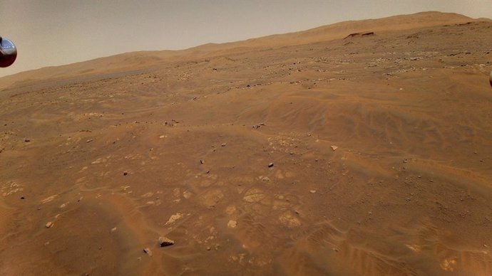 Esta imagen mirando hacia el oeste, hacia la unidad geológica Séítah en Marte, fue tomada desde una altura de 10 metros (33 pies) por el helicóptero Ingenuity Mars de la NASA durante su sexto vuelo, el 22 de mayo de 2021.