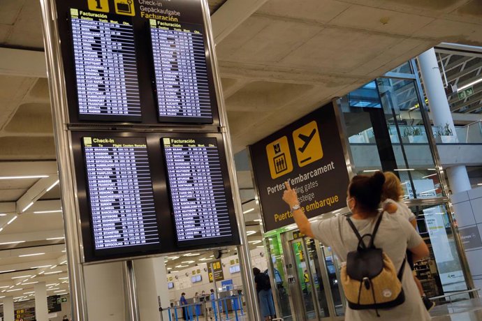 Archivo - 15 August 2020, Spain, Palma: A woman looks at the flight information panel in Palma de Mallorca airport. Germany has declared nearly all of Spain, including the island of Mallorca, as risky areas following a spike of coronavirus cases. Photo: