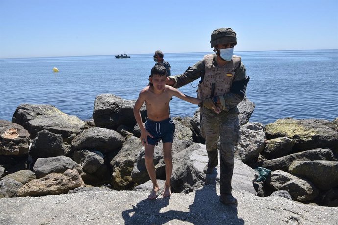 Un militar del ejército español ayuda a un menor migrante procedente de Marruecos a su llegada a Ceuta, a 19 de mayo de 2021, en Ceuta, (España). Los intentos de llegar a Ceuta no han cesado desde el lunes y pasadas 72 horas el balance de migrantes que 