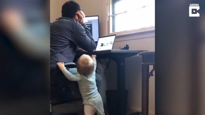 Esta niña de 15 meses cambiando la altura del escritorio de su padre mientras trabaja es un divertido resumen del teletrabajo en pandemia