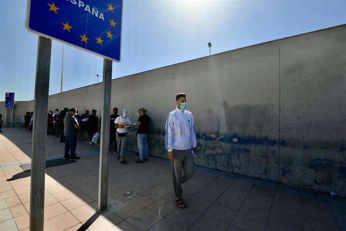 Varios migrantes procedentes de Marruecos hacen cola en las puertas de la frontera de Ceuta