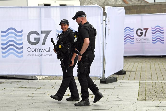 10 June 2021, United Kingdom, Falmouth: Police officers walk through Falmouth's media centre ahead of the G7 summit in Cornwall, which will be held from 11 to 13 June. Photo: Stefan Rousseau/PA Wire/dpa