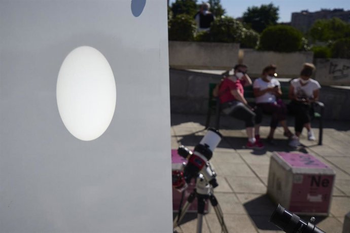 Varias personas acuden a observan el eclipse parcial de sol de este jueves desde la explanada del Planetario de Pamplona