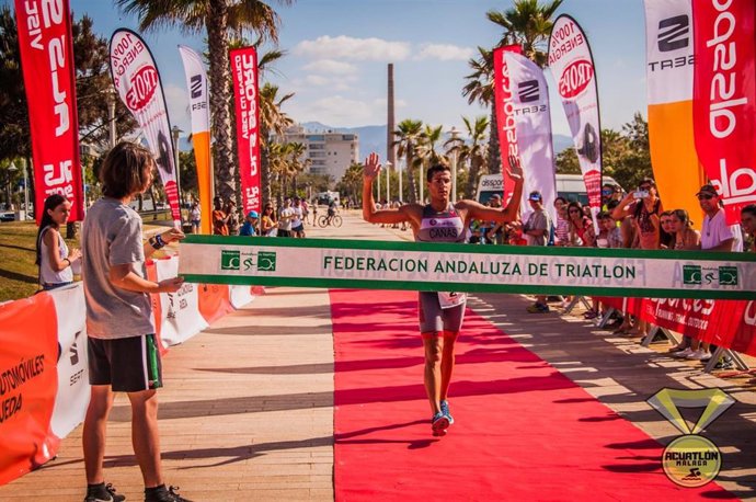 Un triatleta llega a la meta en Málaga, que este domingo celebra el V Acuatlón