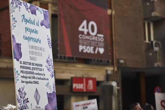 Archivo - Una profesional del sector de la peluquería y estética se concentra con una pancarta frente a la sede del PSOE, en Madrid (España),  