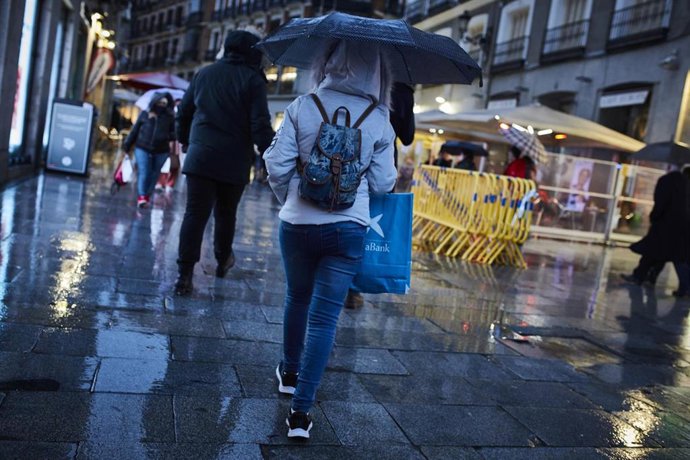 Archivo - Transeúntes caminan cerca de una zona comercial en la calle de Preciados, en Madrid (España), a 27 de noviembre de 2020. 