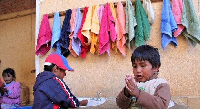 Archivo - Dos niños en Bolivia se lavan las manos en una estación apoyada por UNICEF.