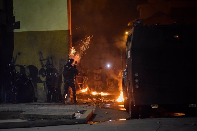 28 May 2021, Colombia, Pasto: A riot police officer shoots a tear gas canister during clashes with demonstrators following a protest against the government of President Ivan Duque Marquez. Colombian President Ivan Duque on Friday night said military ass