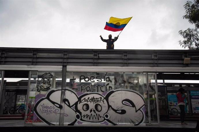 Un hombre ondea una bandera de Colombia