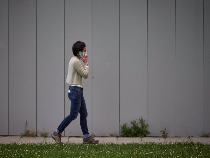 Archivo - Una mujer camina hablando por el móvil 