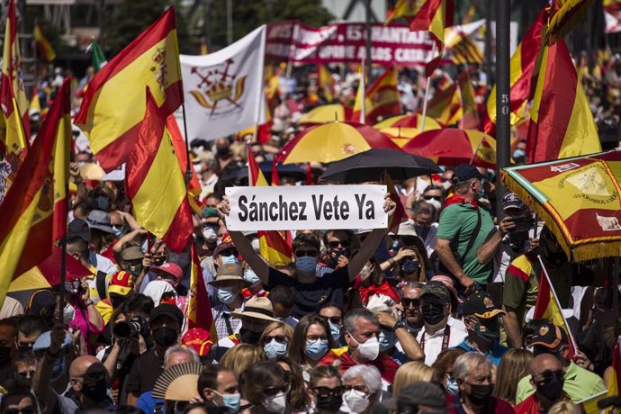 Un hombre con un cartel en el que se lee: `Sánchez vete ya, entre una multitud de personas con banderas de España, participan en una concentración contra los indultos a los presos del procés, en la Plaza de Colón, a 12 de junio de 2021, en Madrid (Espa