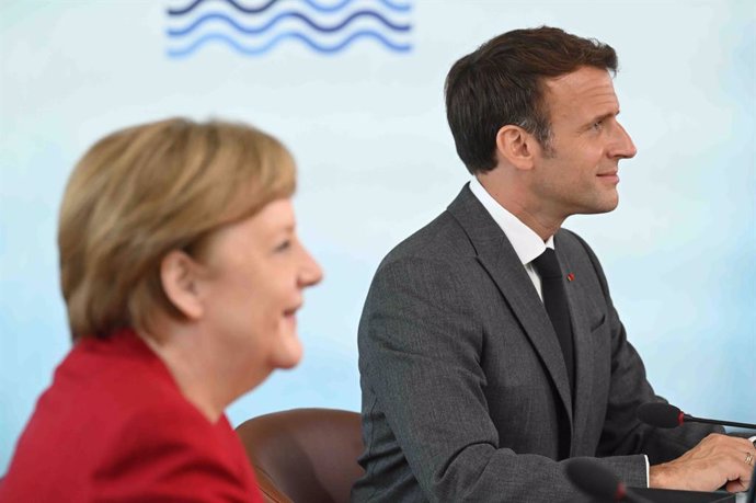 11 June 2021, United Kingdom, Carbis Bay: German Chancellor Angela Merkel (L) and French President Emmanuel Macron attend the G7 summit in Cornwall. Photo: Leon Neal/PA Wire/dpa
