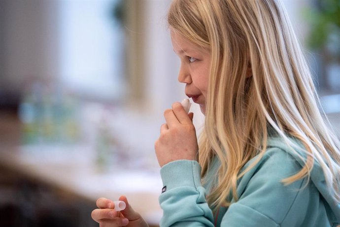 Archivo - 10 March 2021, Bavaria, Munich: Martha (10 years old), a pupil in the fourth grade of an elementary school, puts her saliva sample into a test tube during a self-administered coronavirus test. Photo: Matthias Balk/dpa - ATTENTION: editorial us