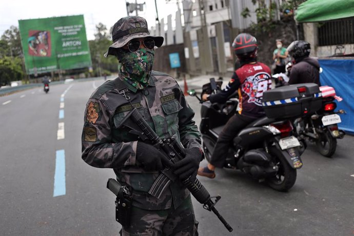 Archivo - 17 March 2020, Philippines, Manila: An armed soldier stands at a checkpoint in Manila. President Duterte has placed the whole of Luzon - the largest island in the Philippines with 57 million people - under "tightened quarantine" and tightened 
