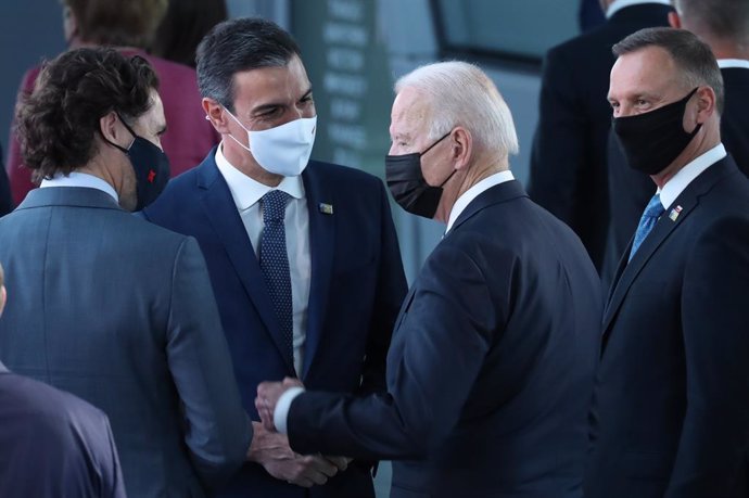 El presidente del Gobierno, Pedro Sánchez, saluda al presidente estadounidense, Joe Biden, y al primer ministro canadiense, Justin Trudeau, en la cumbre de la OTAN