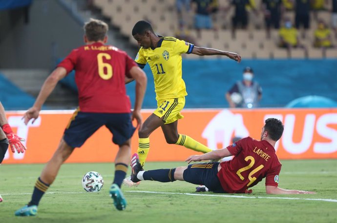 14 June 2021, Spain, Seville: Sweden's Alexander Isak (C)passes the ball between Spain's Marcos Llorente and Aymeric Laporte during the UEFAEURO2020 Group Esoccer match between Spain and Sweden at La Cartuja Stadium. Photo: Cezearo De Luca/dpa