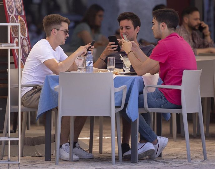 Tres hombres comen en una terraza del centro de la capital.