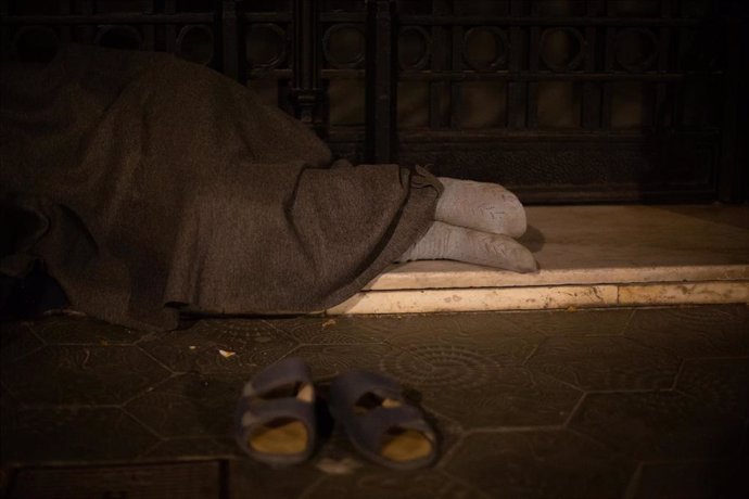 Un hombre sin hogar duerme en una calle de Barcelona.
