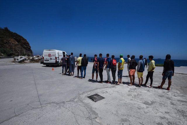 Varios migrantes hacen cola para recibir alimentos de Cáritas Diocesana en Ceuta.
