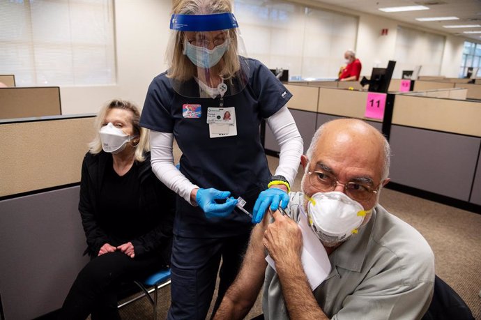 Archivo - 04 February 2021, US, Sacramento: CEO of Sutter Valley Medical Foundations Theresa Frei (C)administers Nasser Kamili with the Pfizer coronavirus (COVID-19) vaccine during a large-scale COVID-19 vaccination at a clinic. Sutter Health is vaccin