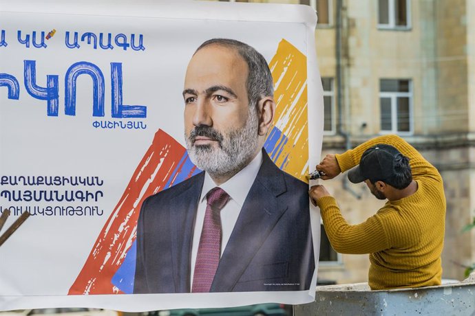 08 June 2021, Armenia, Gyumri: A worker fixes a banner of acting prime minister Nikol Pashinyan of the Civil Contract, ahead of the parliamentary elections in Armenia. Photo: Celestino Arce Lavin/ZUMA Wire/dpa