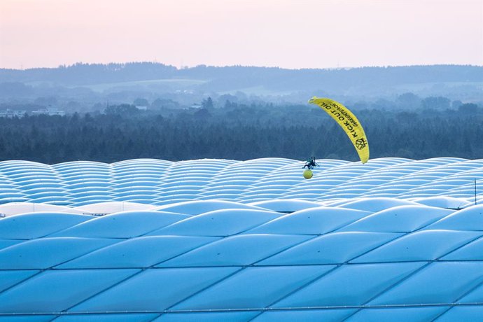 15 June 2021, Bavaria, Munich: A Greenpeace activist flies with a parachute above the Allianz Arena before the start of the UEFAEURO2020 Group Fsoccer match between France and Germany. Photo: Matthias Balk/dpa