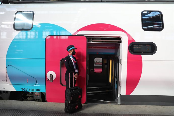 Archivo - Una empleada espera en la puerta de un tren durante la inauguración del primer trayecto de Ouigo