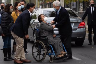 Archivo - El presidente de Chile, Sebastián Piñera, saluda a una mujer después de votar en las elecciones del 15 y el 16 de mayo. 