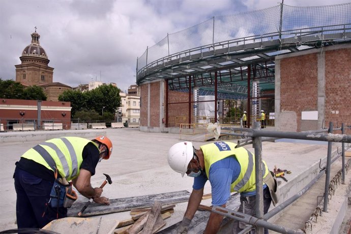 Dos obreros trabajan en las obras de construcción de la nueva estación subterránea de Sant Andreu Comt