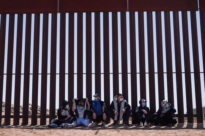 Archivo - FMigrantes solicitantes de asilo se entregan a la Patrulla Fronteriza de Estados Unidos en el muro fronterizo con México en Yuma.