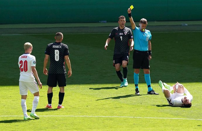 13 June 2021, United Kingdom, London: Croatia's Mateo Kovacic (2nd L) receives the yellow card by referee Daniele Orsato (2nd R) for a foul on England's Mason Mount (R) during the UEFA EURO 2020 Group D soccer match between England and Croatia at Wemble