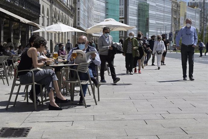 Un grupo de personas charla en la terraza de un local de hostelería de A Coruña