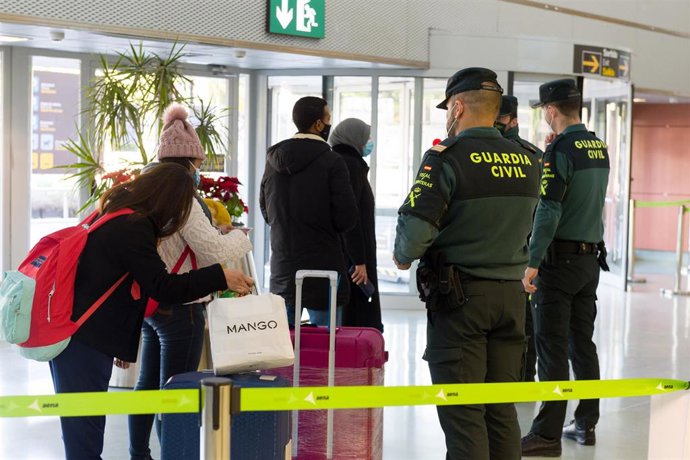 Archivo - Agentes de la Guardia Civil y empleados de seguridad vigilan a los pasajeros en el interior del Aeropuerto de Ibiza.