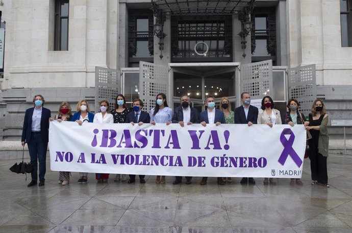 Representantes de los grupos políticos municipales portan una pancarta contra la violencia de género durante el minuto de silencio convocado por el Ayuntamiento de Madrid por el asesinato de una vecina de Moratalaz 