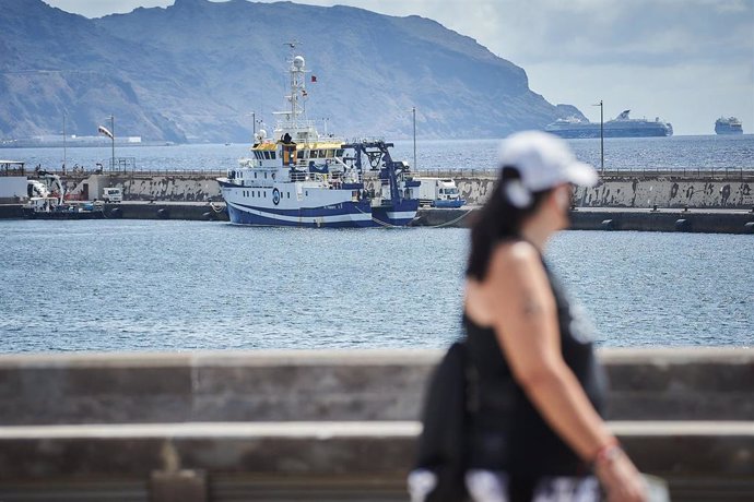 Una mujer pasa por delante del buque oceanográfico 'Ángeles Alvariño' que busca a Anna y Tomás Gimeno