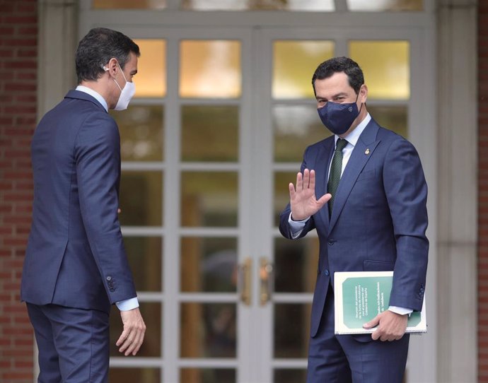 El presidente de la Junta de Andalucía, Juan Manuel Moreno Bonilla (d) saluda a su llegada al Palacio de Moncloa antes de su reunión con el presidente del Gobierno, Pedro Sánchez (i), a 17 de junio de 2021. Se trata de la primera reunión oficial de ambo