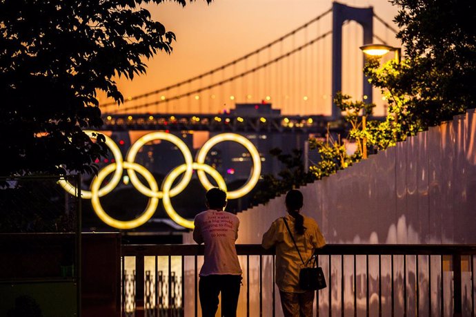 11 June 2021, Japan, Tokyo: Acouple look at the Olympic Rings at Odaiba bay, ahead of the Tokyo 2020 Olympic Games. The Summer Olympics are taking place from 23 July to 8 August 2021. Photo: Rob Walbers/BELGA/dpa